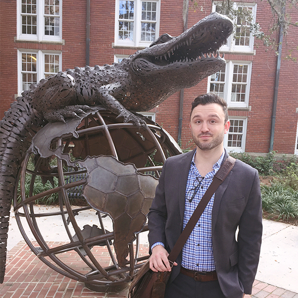 Justin Collier standing in front of Gator statue at University of Florida